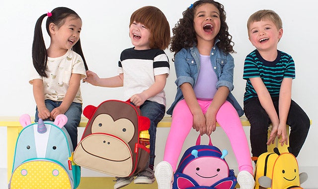 four children carrying Skip Hop bookbags